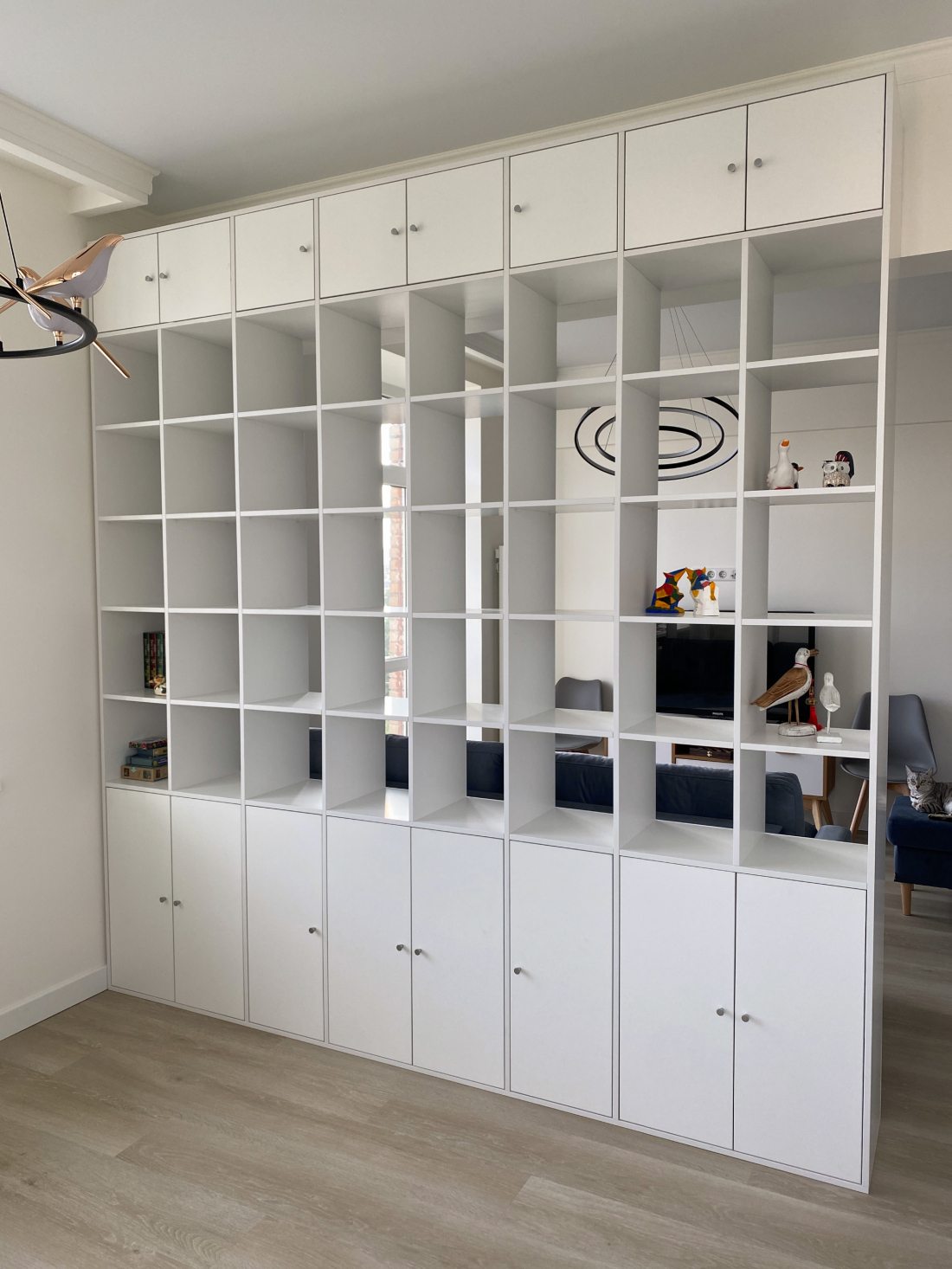 White floor-to-ceiling room divider shelving